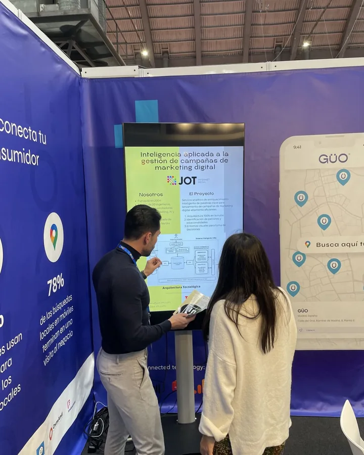 Stand de GÜO en una feria del sector, con la app y una presentación en pantalla